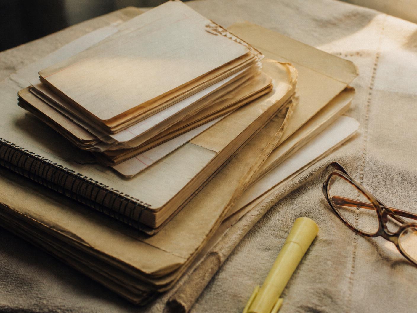 A stack of worn folders, index cards and a spiral notebook — the FIDI research archive
